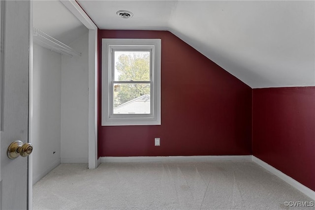 additional living space with visible vents, baseboards, carpet, and lofted ceiling