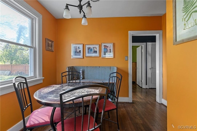 dining area featuring baseboards, a chandelier, and dark wood-style floors