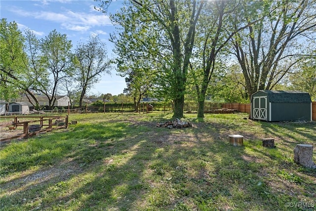 view of yard with a fenced backyard, an outbuilding, and a storage unit