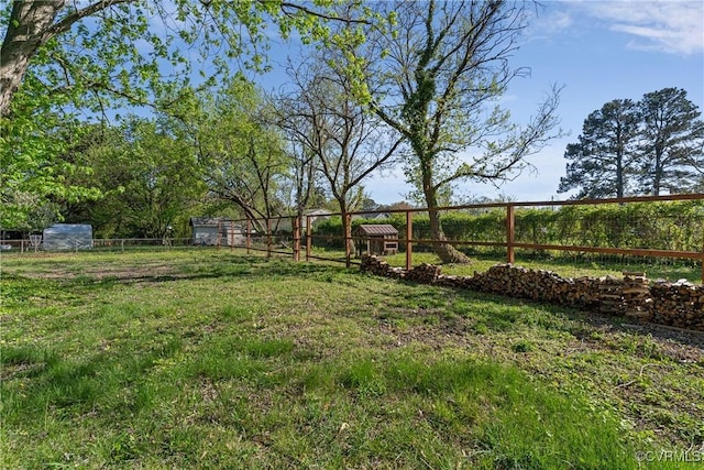 view of yard with an outbuilding and fence