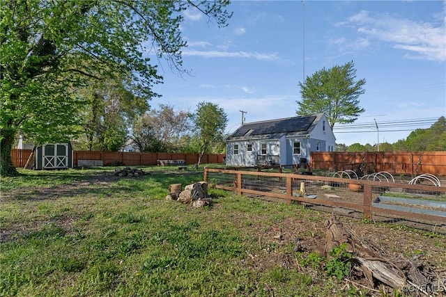 view of yard with an outbuilding, a storage unit, and a fenced backyard