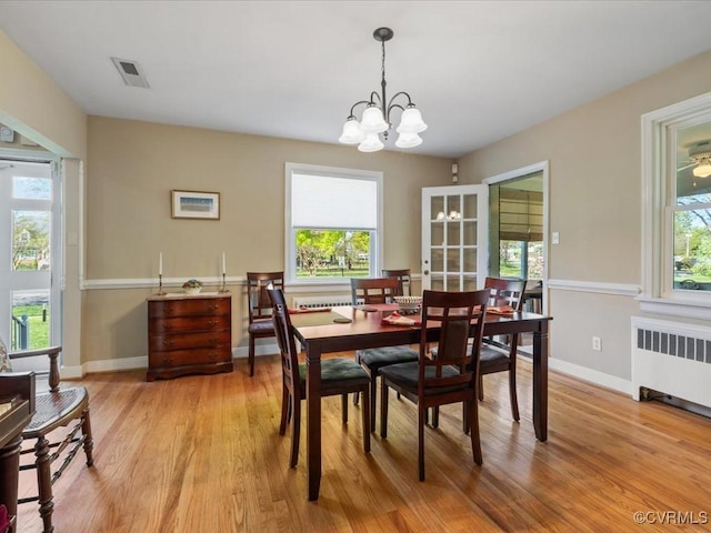 1612 Brookland Pkwy, Richmond, VA 23227 - dining room with radiator heating unit, light wood finished floors, a chandelier, and baseboards