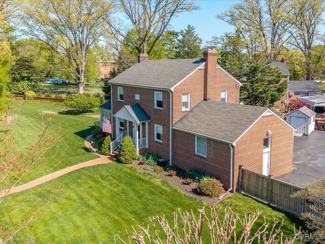 1612 Brookland Pkwy, Richmond, VA 23227 - view of front of home featuring a chimney, brick siding, a front yard, and a shingled roof