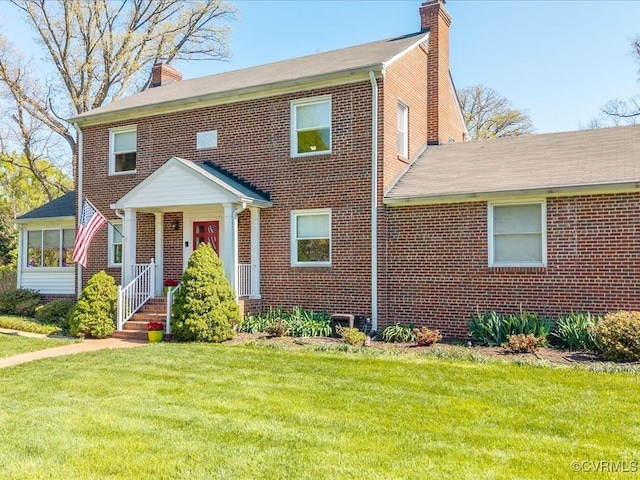 1612 Brookland Pkwy, Richmond, VA 23227 - view of front of house with a chimney, brick siding, a front lawn, and roof with shingles
