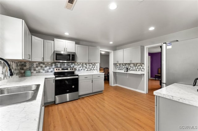 1474 Welsh Tract Rd, Charlotte Courthouse, VA 23923 - kitchen with stainless steel appliances, light wood finished floors, tasteful backsplash, light countertops, and recessed lighting