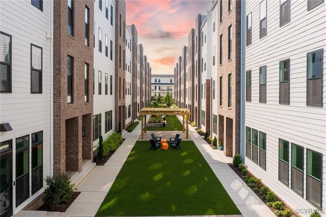view of home's community featuring a lawn and a pergola