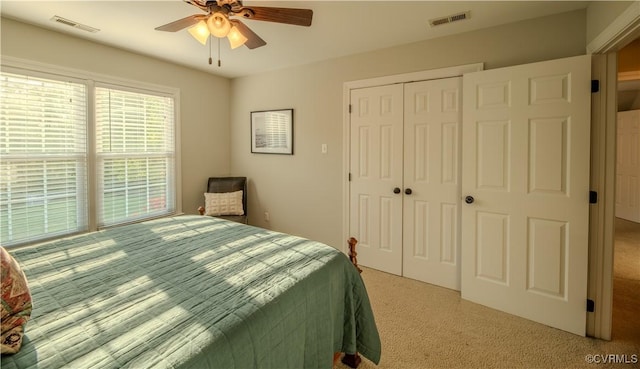 bedroom featuring carpet floors, a ceiling fan, visible vents, and a closet