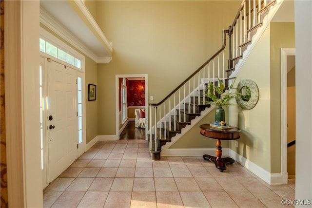 entrance foyer with stairs, baseboards, a wealth of natural light, and light tile patterned floors