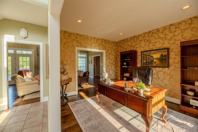 office space featuring wallpapered walls, plenty of natural light, baseboards, and wood finished floors