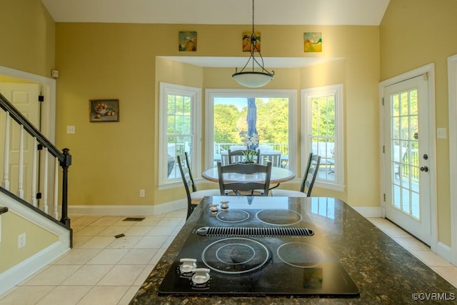 dining room featuring light tile patterned floors, stairs, and a wealth of natural light