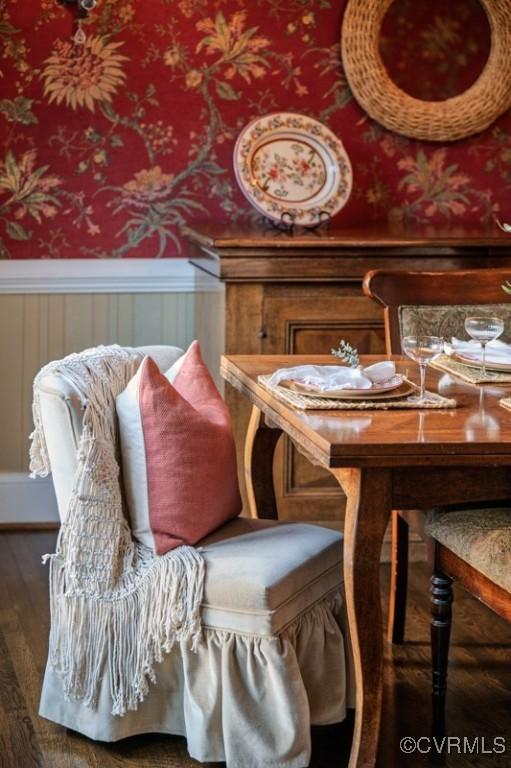 dining area featuring wood finished floors and a wainscoted wall