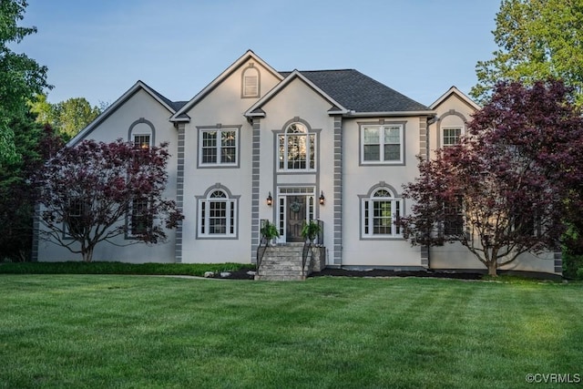 view of front facade with stucco siding and a front lawn