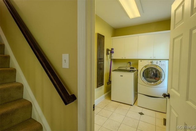 washroom featuring cabinet space, separate washer and dryer, and light tile patterned flooring
