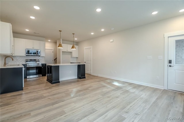 3436 Carlton St Unit 4-5B, Richmond, VA 23230 - kitchen with stainless steel appliances, a sink, a center island, decorative backsplash, and white cabinets