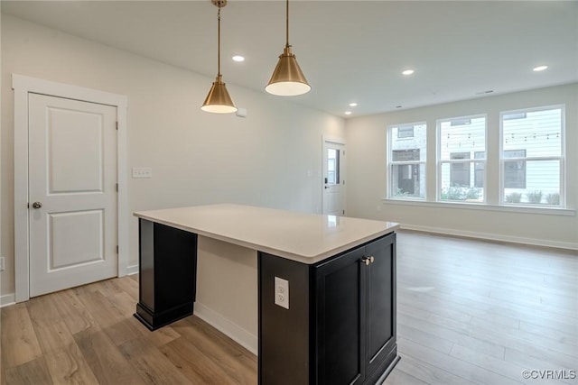 3436 Carlton St Unit 4-5B, Richmond, VA 23230 - kitchen featuring light wood finished floors, dark cabinetry, light countertops, decorative light fixtures, and a kitchen island