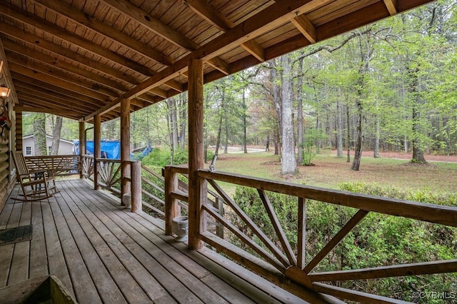 wooden terrace featuring a view of trees