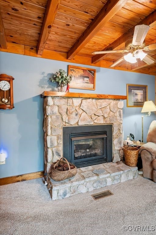 room details with wood ceiling, a stone fireplace, and visible vents