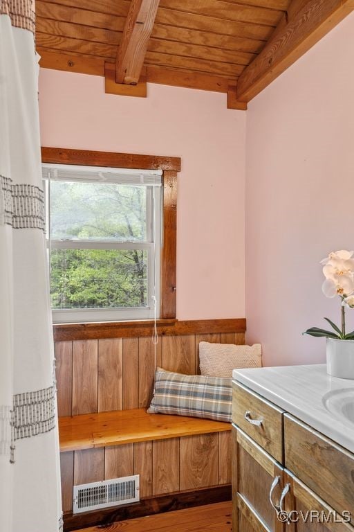 bathroom featuring beamed ceiling, visible vents, wood ceiling, and a sink