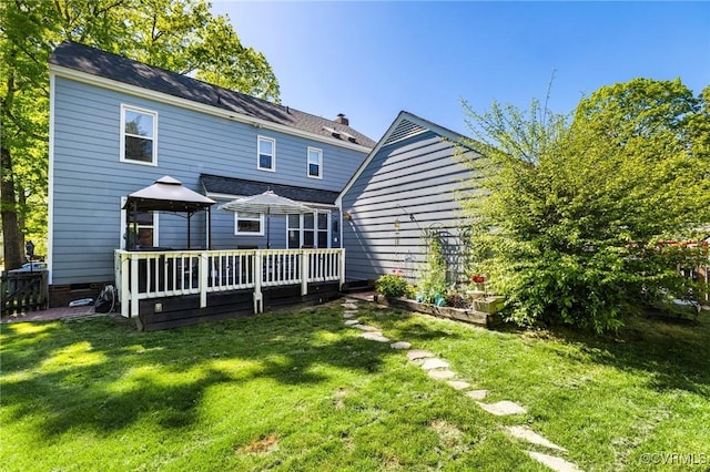 back of property with a gazebo, a lawn, and a deck
