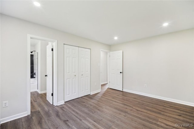 unfurnished bedroom featuring baseboards, a closet, wood finished floors, and recessed lighting