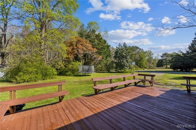 wooden terrace featuring a yard and a trampoline