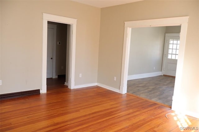 empty room featuring light wood-style floors and baseboards