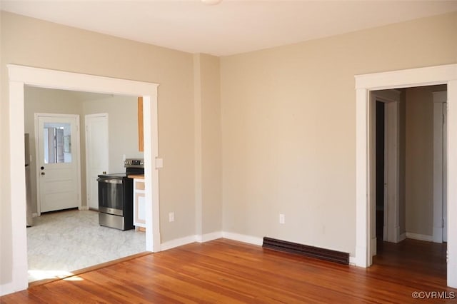 spare room with visible vents, baseboards, and wood finished floors