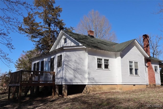 view of side of property featuring a chimney and a deck