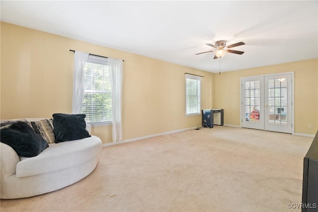 living area with baseboards, a ceiling fan, carpet, and french doors