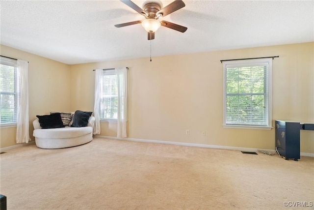 sitting room with carpet flooring, a textured ceiling, baseboards, and ceiling fan