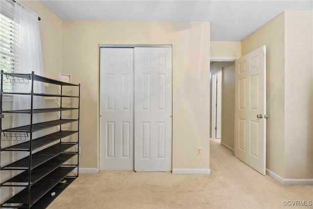 unfurnished bedroom with baseboards and light carpet