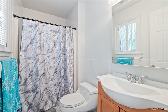 bathroom with toilet, tile walls, a shower with shower curtain, and vanity