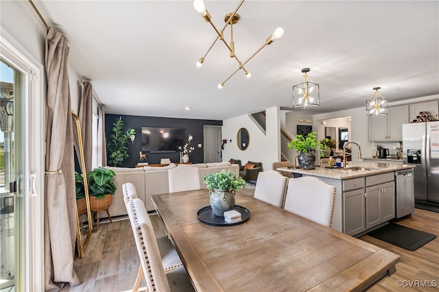dining space with wood finished floors and a chandelier