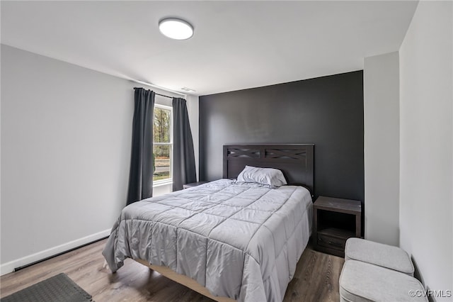 bedroom featuring baseboards and wood finished floors