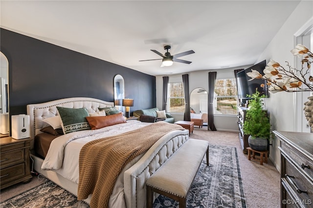 bedroom featuring arched walkways, a ceiling fan, and carpet flooring