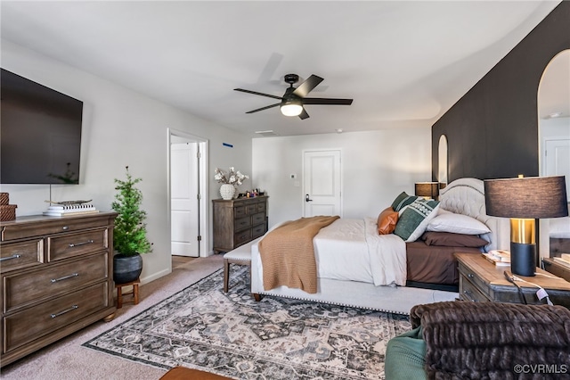 bedroom featuring ceiling fan, arched walkways, light colored carpet, baseboards, and visible vents