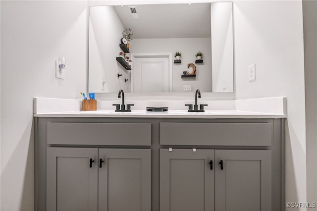 bathroom featuring double vanity, visible vents, and a sink