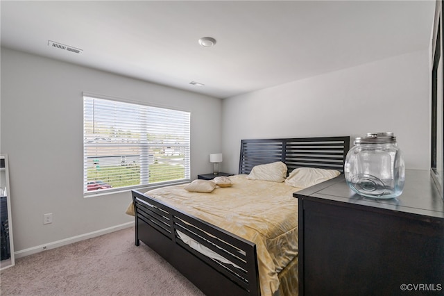 bedroom with baseboards, visible vents, and carpet
