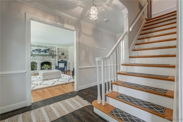 12665 Petersburg St, Chester, VA 23831 - staircase featuring an inviting chandelier, a fireplace, ornamental molding, wood finished floors, and baseboards
