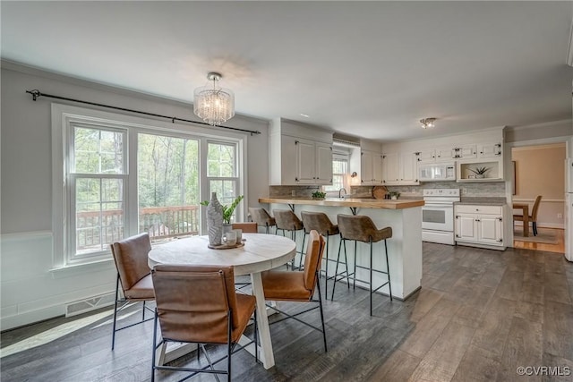 12665 Petersburg St, Chester, VA 23831 - dining space with crown molding, plenty of natural light, a notable chandelier, and dark wood-style floors