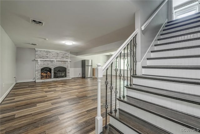 12665 Petersburg St, Chester, VA 23831 - stairs with baseboards, wood finished floors, a brick fireplace, and visible vents