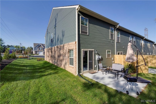 rear view of house featuring a patio area and a yard