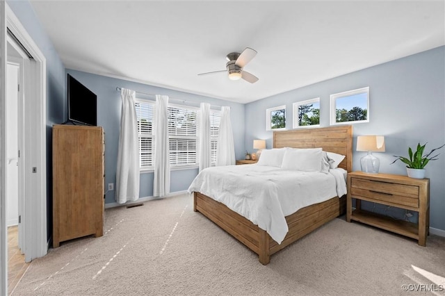 bedroom with carpet floors, baseboards, ceiling fan, and visible vents