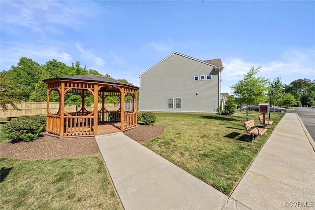 view of property exterior featuring fence, a gazebo, and a yard