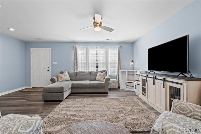 living room with baseboards, ceiling fan, and wood finished floors