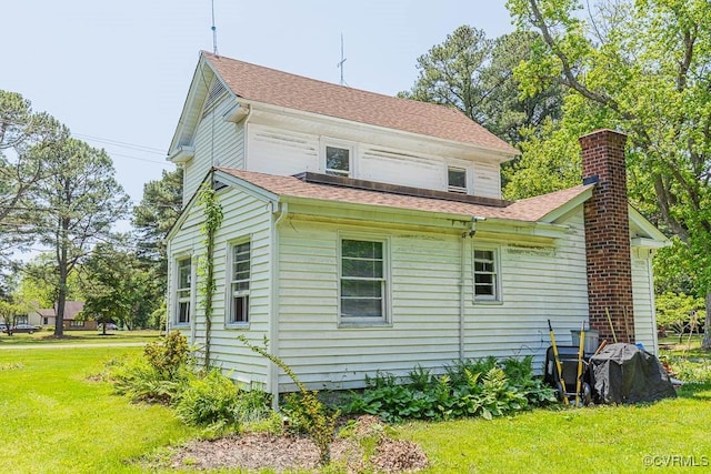 back of property with a yard and a chimney