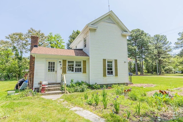 back of property featuring a lawn and a chimney