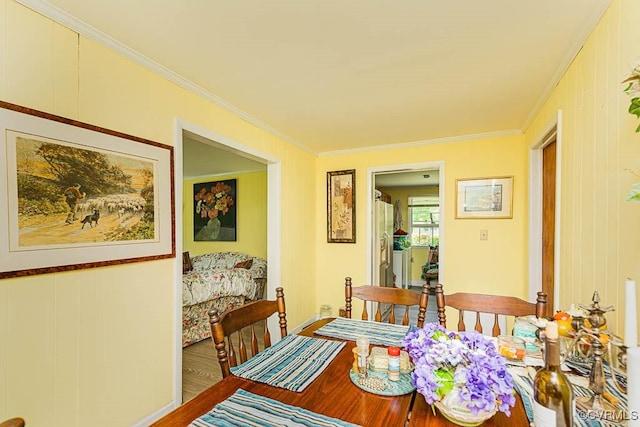 dining area with crown molding and wood finished floors