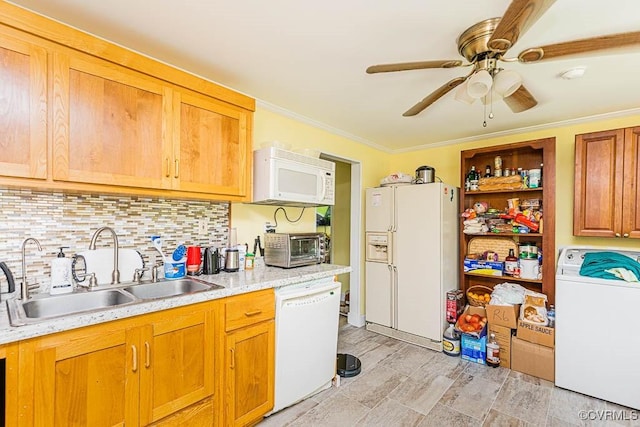 kitchen featuring washer / clothes dryer, white appliances, light countertops, backsplash, and a sink