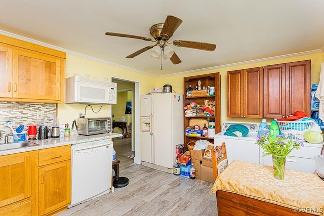 kitchen with washer / clothes dryer, tasteful backsplash, white appliances, ceiling fan, and a sink